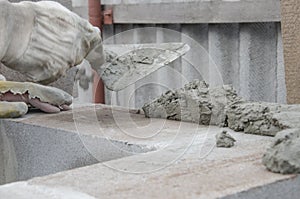 Worker aligns with a spatula, lay brick cinderblocks photo