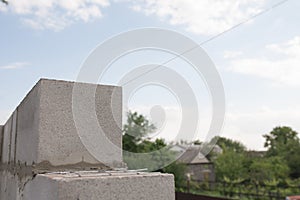 Worker aligns with a spatula, lay brick cinderblocks photo
