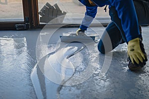 The worker applies gray epoxy resin to the new floor photo