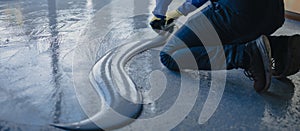 The worker applies gray epoxy resin to the new floor photo