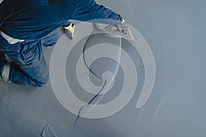 The worker applies gray epoxy resin to the new floor