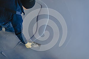 The worker applies gray epoxy resin to the new floor