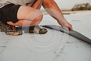 Worker applies pvc membrane roller on roof