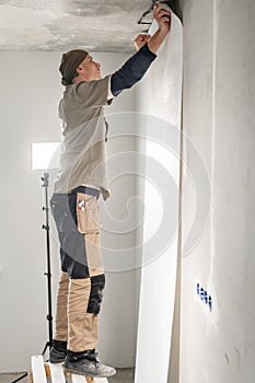 Worker applies a sheet of Wallpaper. Man glueing wallpapers on concrete wall. Repair the apartment. Home renovation