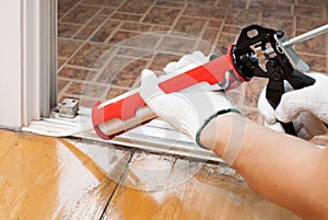 Worker applies silicone caulk on the floor for sea photo