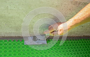 Worker applies waterproofing with a small brush photo