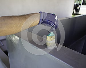 Worker applies waterproofing with a small brush photo