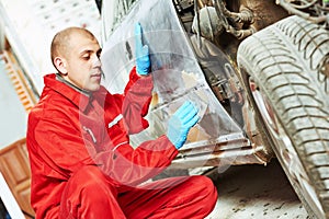 Worker applying car body repair putty