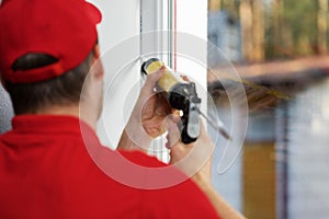 Worker applying caulk around window frame