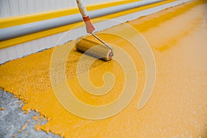 Worker applying epoxy and polyurethane flooring system photo