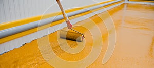 Worker applying epoxy and polyurethane flooring system