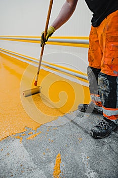 Worker applying epoxy and polyurethane flooring system