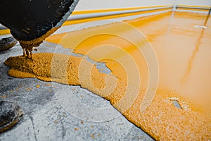 Worker applying epoxy and polyurethane flooring system