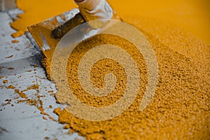 Worker applying epoxy and polyurethane flooring system