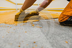 Worker applying epoxy and polyurethane flooring system