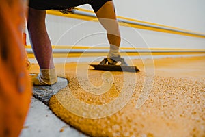 Worker applying epoxy and polyurethane flooring system