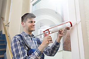 Worker Applying Glue With Silicone Gun photo