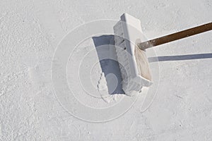 Worker applying white roof coating photo