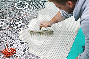 Worker applying tile adhesive on the floor photo