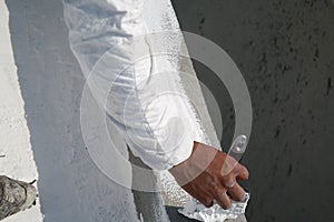 Worker applying white roof coating