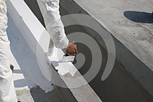 Worker applying white roof coating