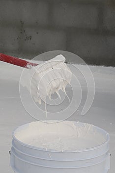 Worker applying white roof coating