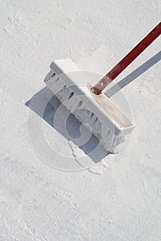 Worker applying white roof coating