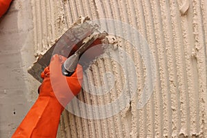 Worker applying white thinset mortar photo