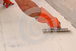Worker applying white thinset mortar photo
