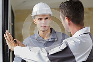 Worker and apprentice installing new window