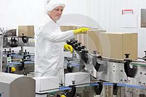 Worker in apron, cap at production line in factor photo