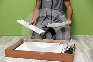 Worker assembles furniture in the kitchen.