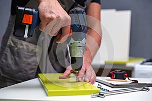 Worker assembles furniture in the kitchen.