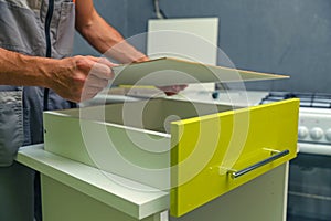 Worker assembles furniture in the kitchen.