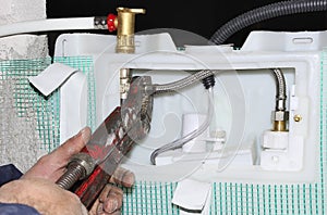Worker assembles a manifold water system / heat with focus on hands or tool