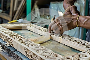 worker assembling a handcarved wooden frame for a mirror