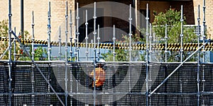 Worker assembling scaffolding on new social housing home unit block at 56-58 Beane St. Gosford, Australia. February 22, 2021. Part