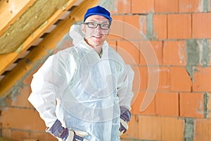 Worker attaching thermal insulation to roof photo