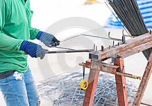 The worker is bending rebars rods with gloves