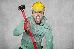 A worker with a big hammer screams like a possessed man