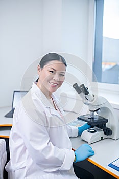 Worker of biochemical laboratory sitting at the table
