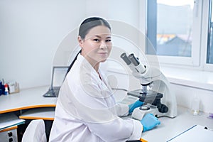 Worker of biochemical laboratory working with microscope