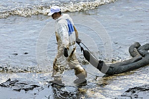 A Worker in biohazard suits used Oil Containment boom as cleani