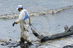 A Worker in biohazard suits used Oil Containment boom as cleani