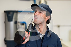 Worker blowing on a screwer