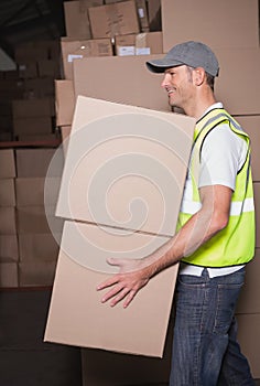 Worker with boxes in warehouse