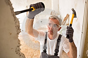 Worker builder demolish wall with tool