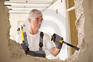 Worker builder demolish wall with tool