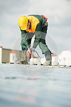 Worker builder roofer at metal profile work