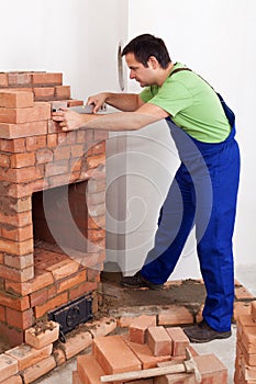 Worker building brick stove or fireplace